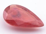 a close up of a red quartz stone on a white surface