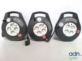 Trois types différents de prises électriques sont représentés sur une surface blanche.