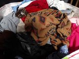 a pile of clothes that is sitting on a bed