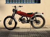a red motorcycle parked next to a building with a blue window