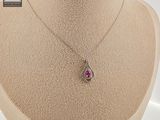 a close up of a necklace on a mannequin with a pink stone