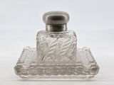 a clear glass bottle with a silver lid on a tray