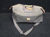 the duffel bag is sitting on a black surface with a black background