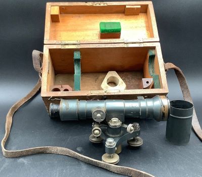 une boîte en bois sur laquelle sont posés un appareil photo et une pipe