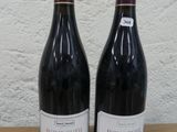 deux bouteilles de vin posées sur une table l'une à côté de l'autre