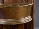 a large copper bathtub sitting on a wooden stand