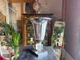a silver vase sitting on top of a black table