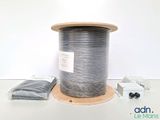 a spool of silver wire on a white table