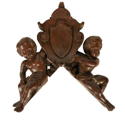 une image représentant une horloge en bois sur laquelle figurent deux chérubins
