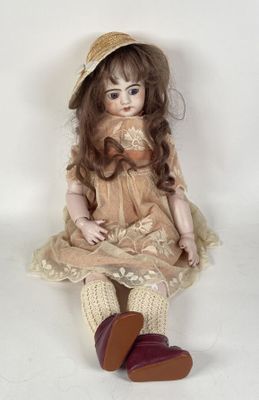 a doll that is sitting on the ground wearing a hat