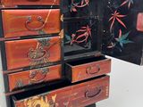 a small chest of drawers with a dragon design on it