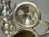 a silver tray with a silver tea pot and a silver tea pot