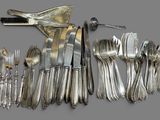 a lot of silverware on a table with a knife and fork