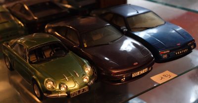 Plusieurs petites voitures sont exposées dans une vitrine.