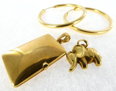 gold plated elephant locke and ring set on a white surface
