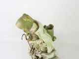 a figurine of a frog sitting on top of a rock