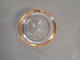a clear glass with a gold rim sitting on a white surface