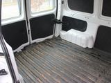 the interior of a white van with the door open and the floor covered in dirt
