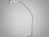 une lampe blanche reliée à un cordon, sur fond gris