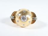 an image of a gold and diamond ring on a white surface