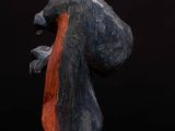 a statue of a man holding a bag on top of a wooden table