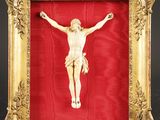 une image de Jésus sur la croix, dans un cadre doré, sur fond rouge
