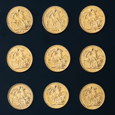 six gold sovereigns of different sizes and shapes on a black surface