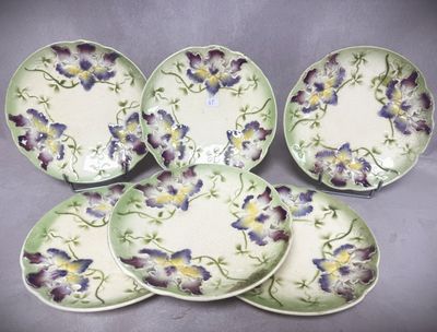 quatre assiettes ornées de fleurs violettes et jaunes, posées sur une table