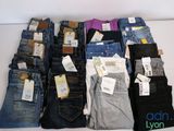 beaucoup de jeans empilés les uns sur les autres sur une table