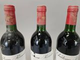 three bottles of red wine are lined up on a table