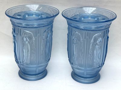 une paire de vases en verre bleu posés sur une table blanche