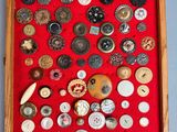 many buttons in a wooden box on a red surface
