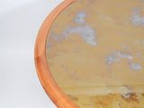 a round wooden table with a mirror on it