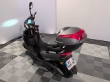 a motor scooter that is parked on a checkered floor