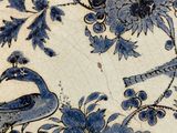 a blue and white plate with a bird and flowers on it