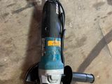 a drill on the floor next to a piece of wood