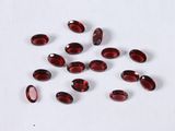 a close up of a bunch of red glass beads on a white surface
