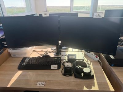 a desk with two computer monitors and a keyboard on it