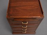 a small wooden box with three drawers on top of it