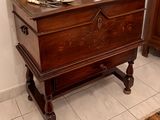 a wooden chest with a lamp on top of it