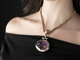 une femme portant un collier orné d'une pierre violette