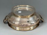 a silver bowl with a lid on a table
