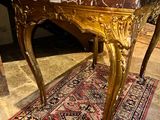 a wooden table with a marble top on a rug