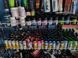 many different colors of paint on the shelves in the store