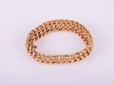 a close up of a gold bracelet on a white background