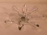 a clear glass flower shaped object on a white surface
