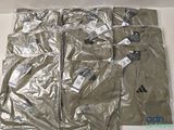 six paires de pantalons dans une boîte posée par terre