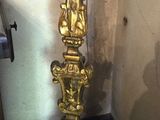 une horloge en or posée sur un socle dans un coin de la pièce