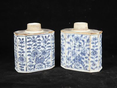 pair of blue and white jars with floral designs on them on a black background