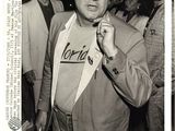 black and white photograph of a man in a suit with a t - shirt on